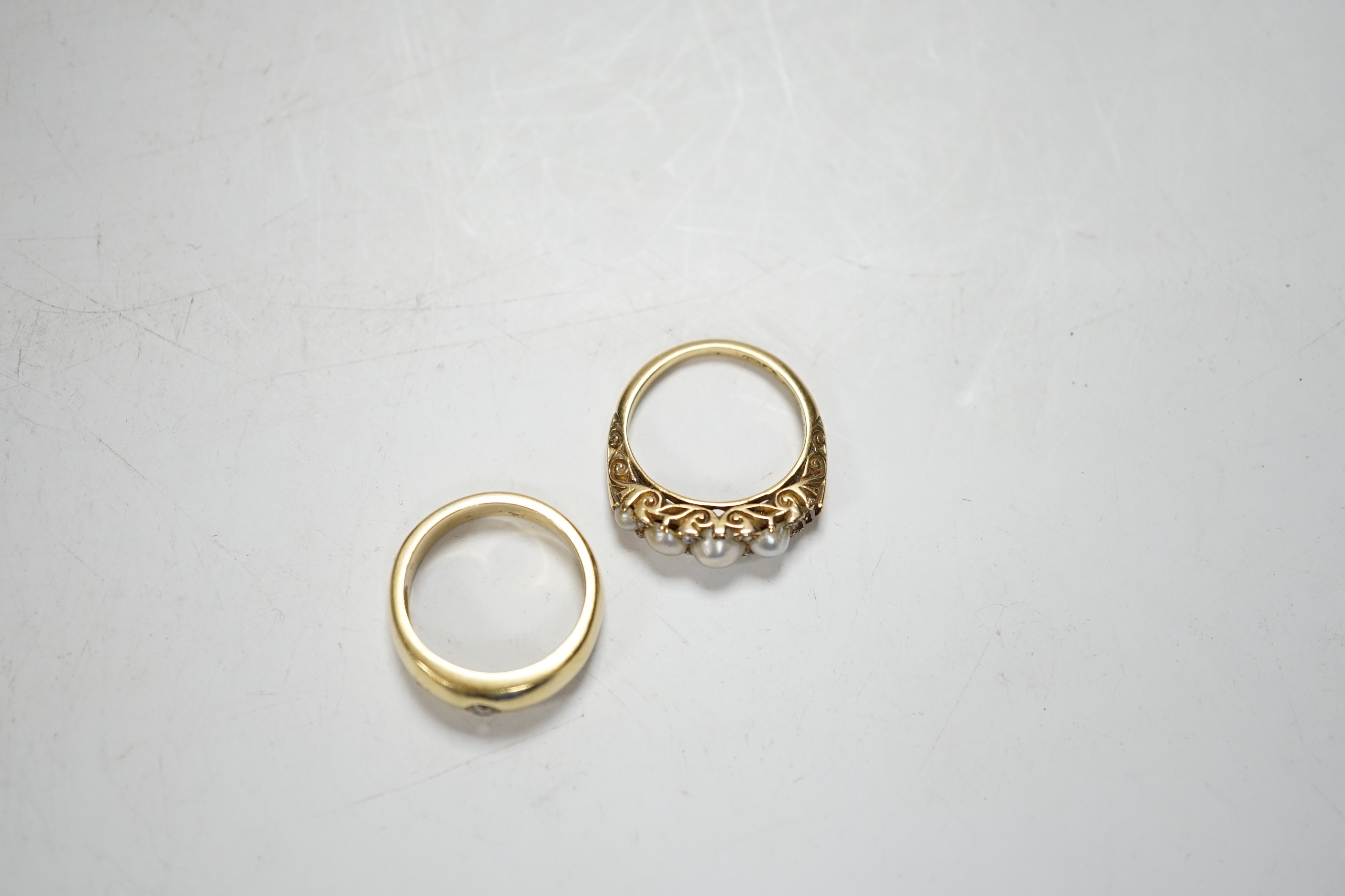 An early 20th century yellow metal and graduated split pearl set half hoop ring, with diamond chip spacers (pearl missing), size K/L, gross weight 4.5 grams, together with a yellow metal and gypsy set solitaire diamond r